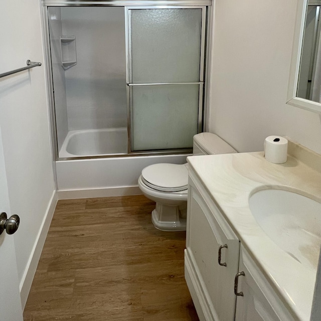 full bathroom featuring shower / bath combination with glass door, vanity, toilet, and wood-type flooring