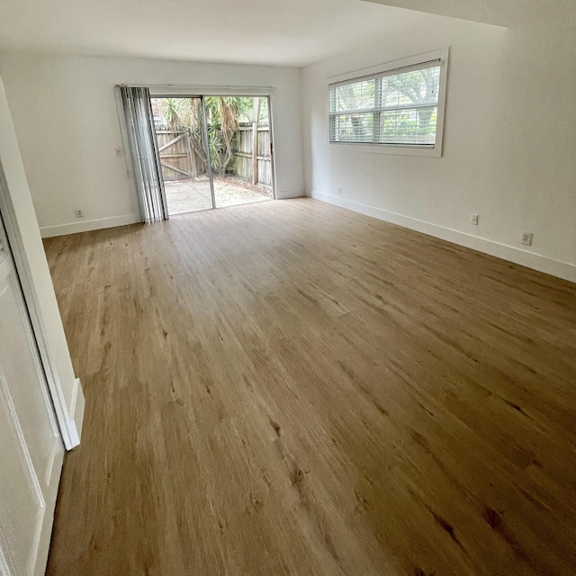 spare room featuring a healthy amount of sunlight and hardwood / wood-style flooring