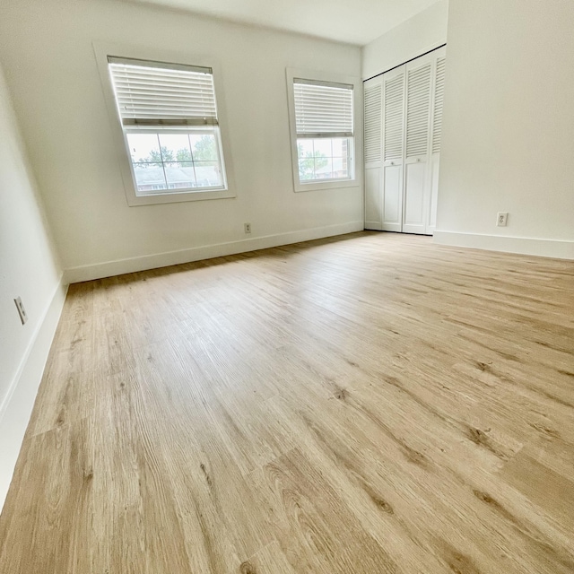 unfurnished bedroom featuring light wood-type flooring and a closet