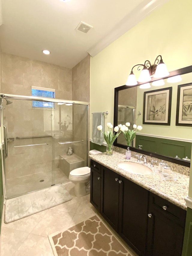 bathroom with tile patterned flooring, a shower with door, toilet, vanity, and ornamental molding