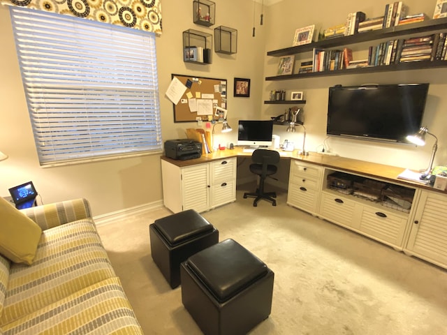 carpeted office space with built in desk