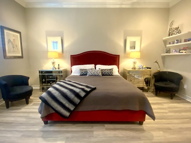 bedroom featuring crown molding and light wood-type flooring