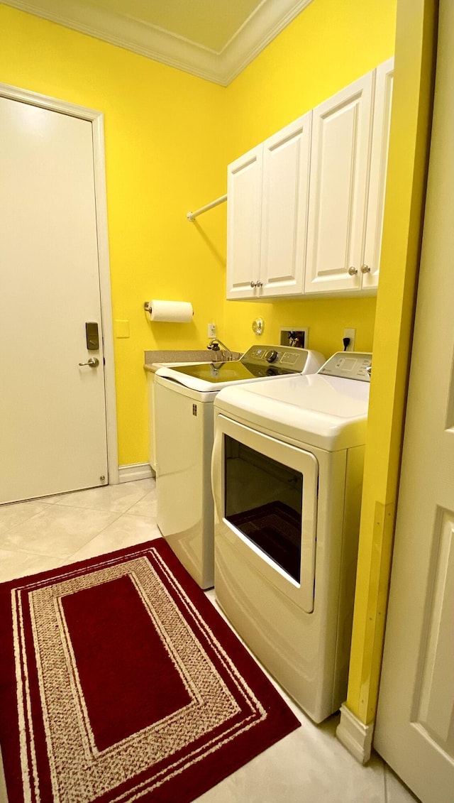 laundry room with light tile patterned floors, crown molding, cabinets, and washing machine and dryer