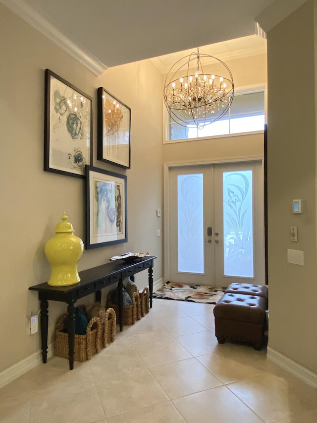 entryway featuring tile patterned flooring, an inviting chandelier, crown molding, and french doors