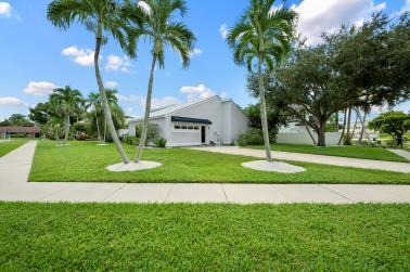 view of property's community featuring a yard and a garage