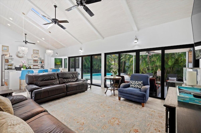 living room with ceiling fan with notable chandelier, beam ceiling, light hardwood / wood-style floors, high vaulted ceiling, and a skylight