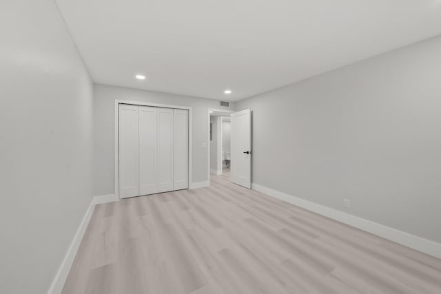 unfurnished bedroom featuring light wood-type flooring and a closet