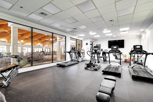 gym with a paneled ceiling and ornamental molding