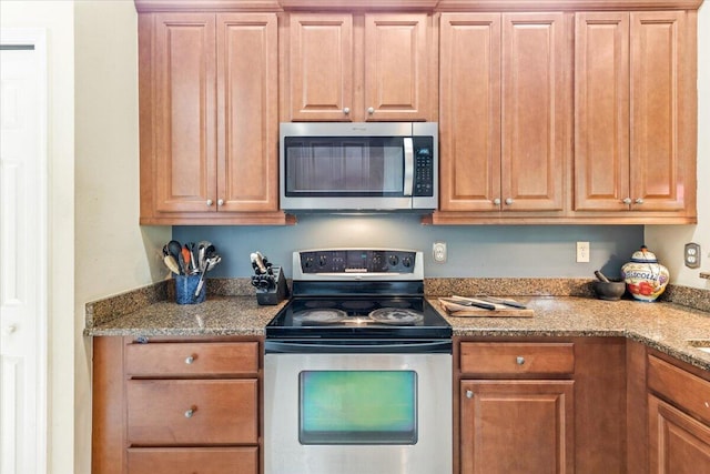 kitchen with appliances with stainless steel finishes and stone countertops