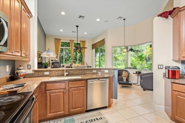 kitchen with kitchen peninsula, sink, appliances with stainless steel finishes, and ceiling fan