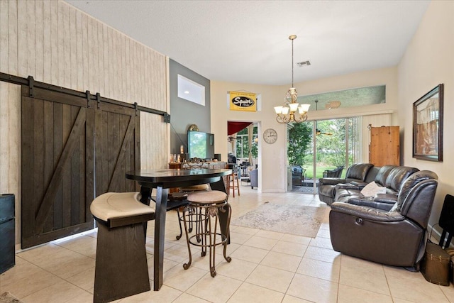 dining room featuring a barn door, wood walls, a notable chandelier, and light tile patterned flooring