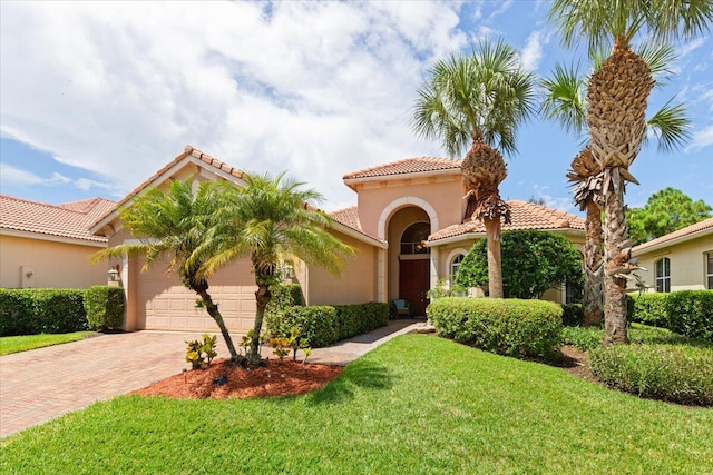 mediterranean / spanish house featuring a garage and a front yard