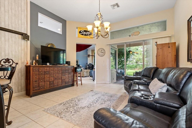 living room featuring a high ceiling, ceiling fan with notable chandelier, light tile patterned floors, and wooden walls