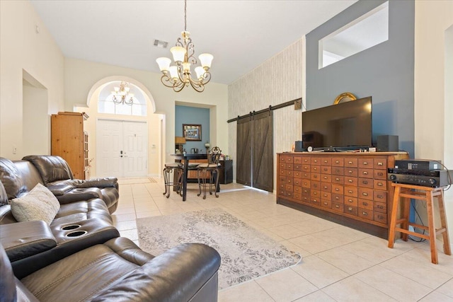 living room with light tile patterned flooring, an inviting chandelier, and a barn door