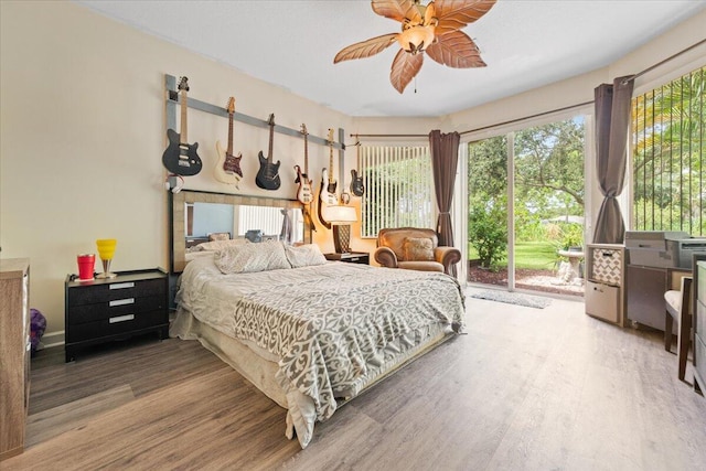 bedroom with wood-type flooring, access to exterior, and ceiling fan