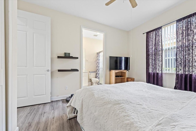 bedroom with ensuite bath, light wood-type flooring, and ceiling fan