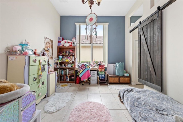 playroom featuring a barn door and light tile patterned floors