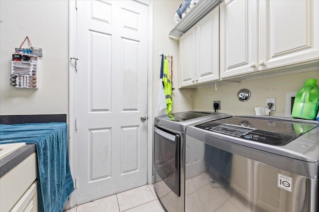 laundry area with cabinets, independent washer and dryer, and light tile patterned flooring