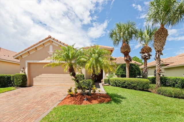 mediterranean / spanish-style home with a garage and a front lawn