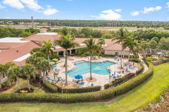 view of pool with a patio area and a lawn