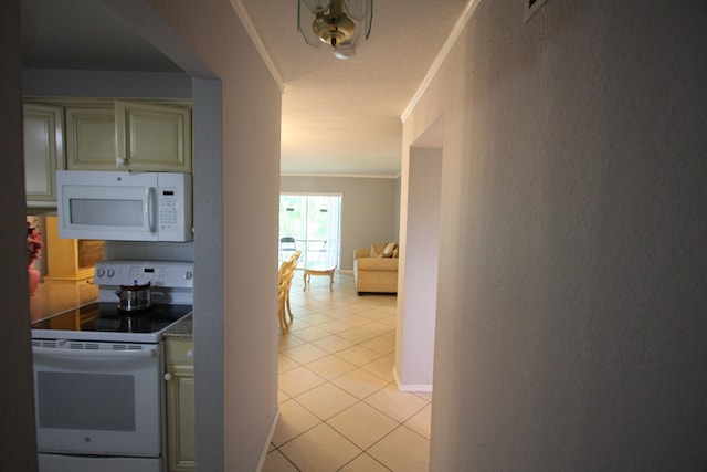 kitchen featuring crown molding, white appliances, light tile patterned floors, and cream cabinets