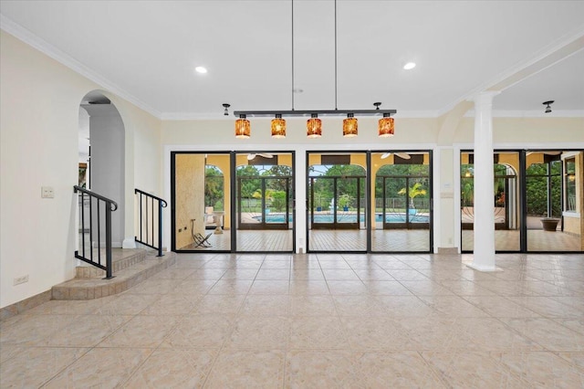 empty room with a healthy amount of sunlight, decorative columns, and ornamental molding