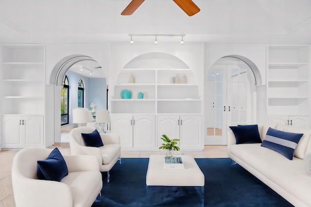 tiled living room featuring ceiling fan, rail lighting, and built in features