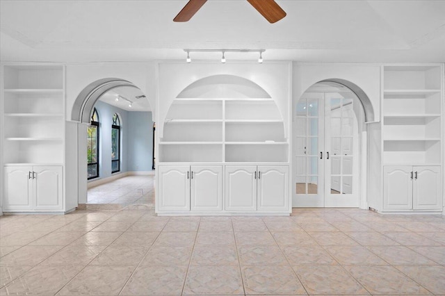 empty room featuring french doors, built in shelves, light tile patterned flooring, and ceiling fan