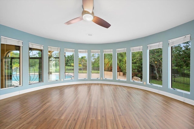 unfurnished sunroom with ceiling fan and a healthy amount of sunlight