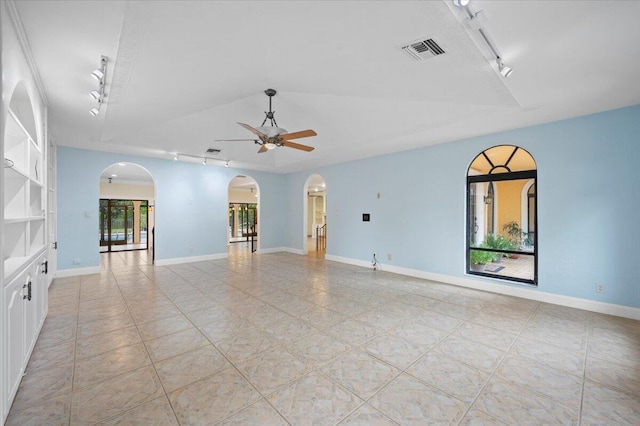 empty room with light tile patterned flooring, ceiling fan, and track lighting