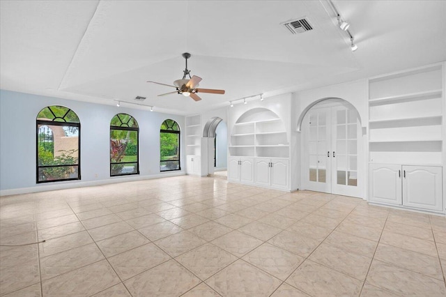 tiled spare room with ceiling fan, french doors, built in shelves, and track lighting