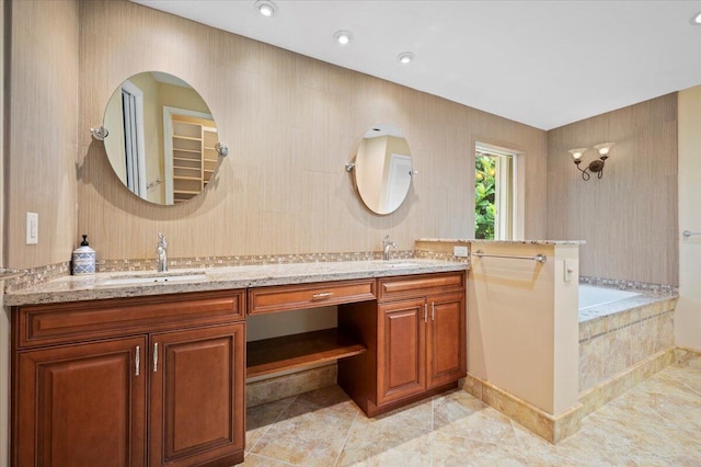 bathroom with tiled tub and vanity