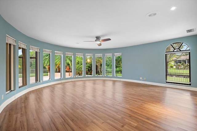 spare room with ceiling fan, plenty of natural light, and light hardwood / wood-style floors