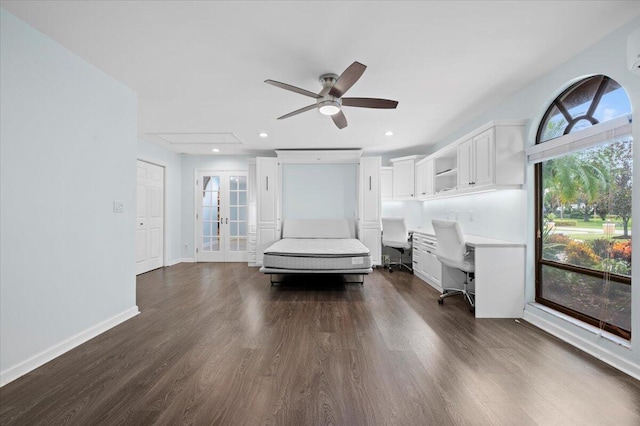 unfurnished bedroom with french doors, multiple windows, dark wood-type flooring, and ceiling fan