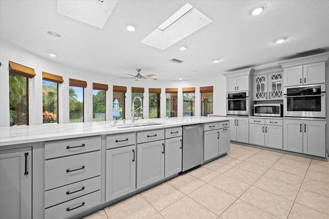 kitchen featuring sink, stainless steel appliances, and gray cabinetry