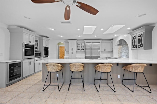 kitchen with wine cooler, stainless steel appliances, a breakfast bar area, and kitchen peninsula