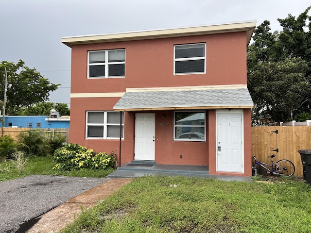 1010 Adams St, West Palm Beach, FL 33407 - view of front of house with stucco siding and roof with shingles