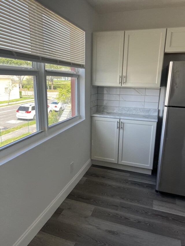 1010 Adams St, West Palm Beach, FL 33407 - unfurnished dining area with healthy amount of natural light, dark wood-style floors, and baseboards