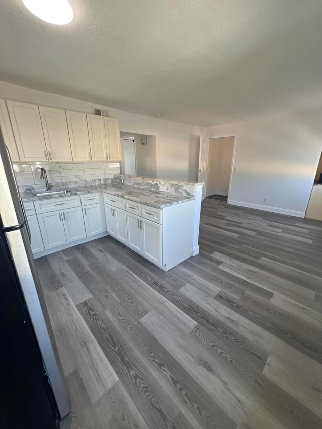 kitchen featuring dark wood-type flooring, decorative backsplash, white cabinetry, and sink