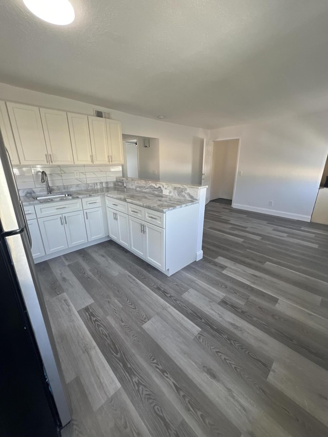 1010 Adams St, West Palm Beach, FL 33407 - kitchen featuring a sink, dark wood-style flooring, white cabinets, and a peninsula