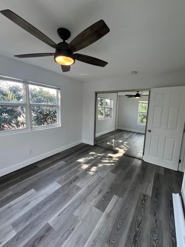 unfurnished bedroom with ceiling fan, a closet, and dark hardwood / wood-style flooring