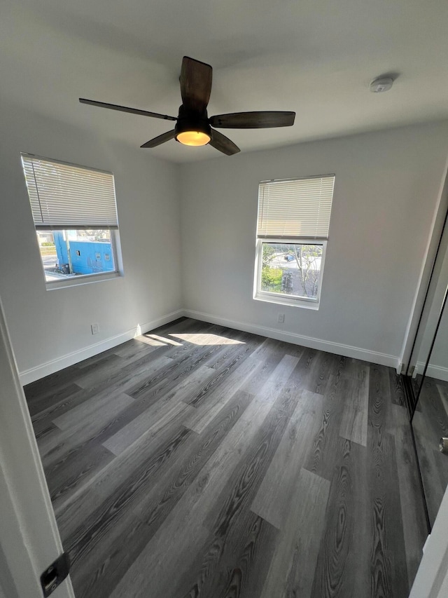 unfurnished room with dark wood-type flooring and ceiling fan