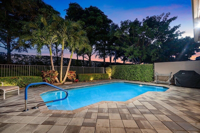 pool at dusk with a patio