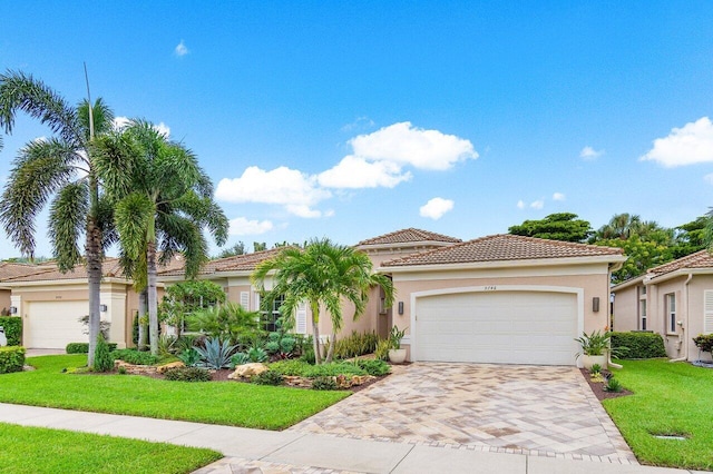 mediterranean / spanish-style home featuring a garage and a front yard