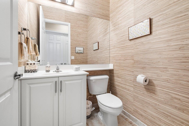 bathroom with vanity, toilet, tile walls, and tile patterned floors