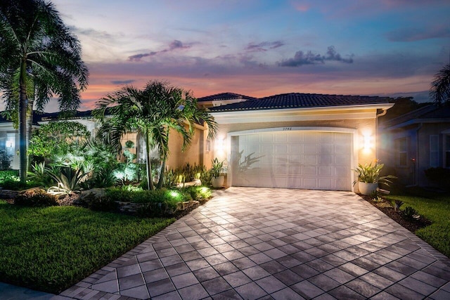 view of front of property with a garage and a yard