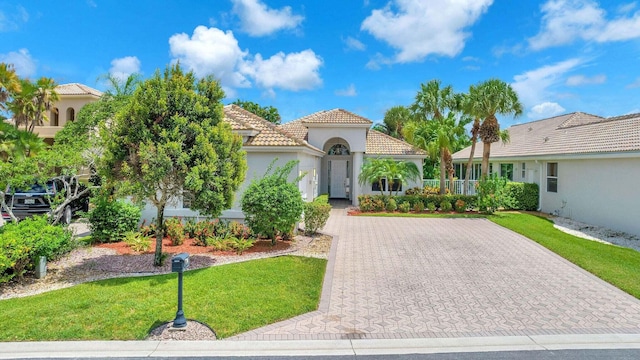 mediterranean / spanish-style house featuring a front yard