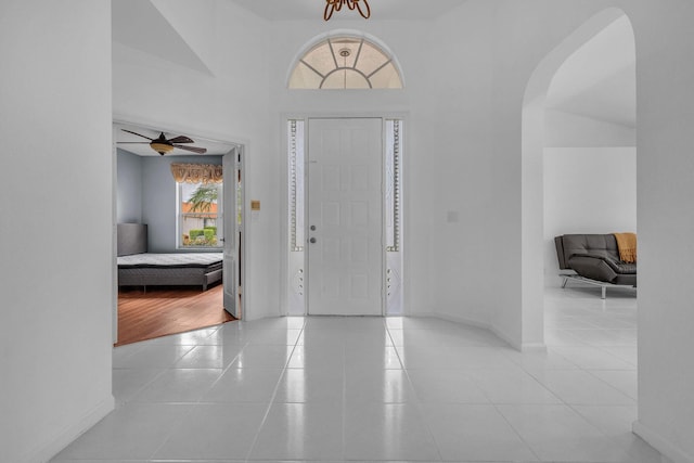 tiled foyer with lofted ceiling and ceiling fan