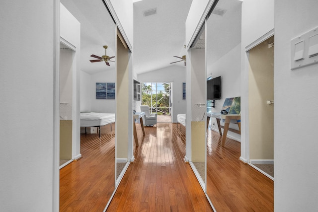 hall with high vaulted ceiling and wood-type flooring