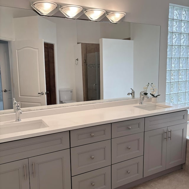 bathroom with vanity, walk in shower, toilet, and tile patterned flooring